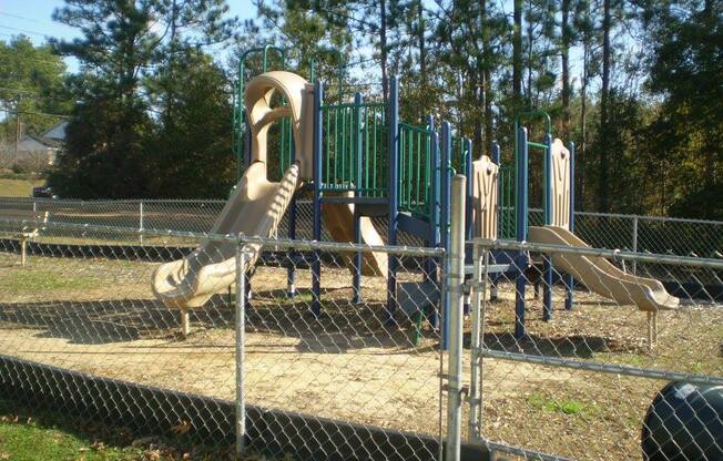 fenced play area with modern playground equipment