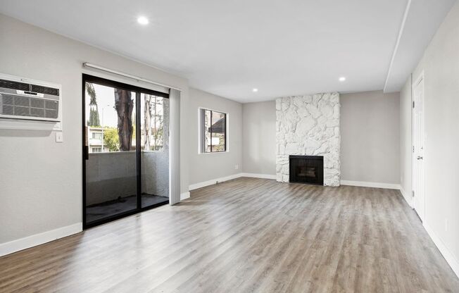 a living room with a fireplace and a glass door