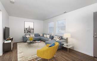 a living room with a gray couch and a yellow chair