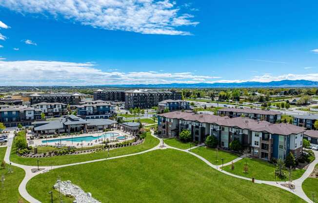 an aerial view of an apartment complex with a pool and green lawn at Arbour Commons, Colorado, 80023