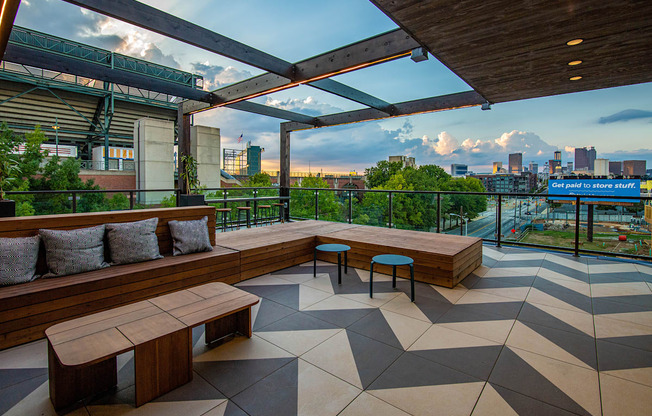 a rooftop terrace with benches and a view of the city