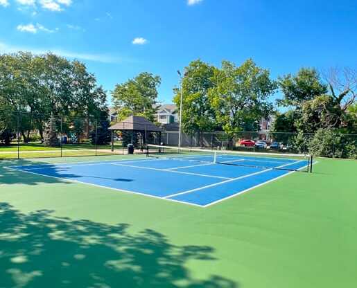 a blue and green tennis court with a black scoreboard