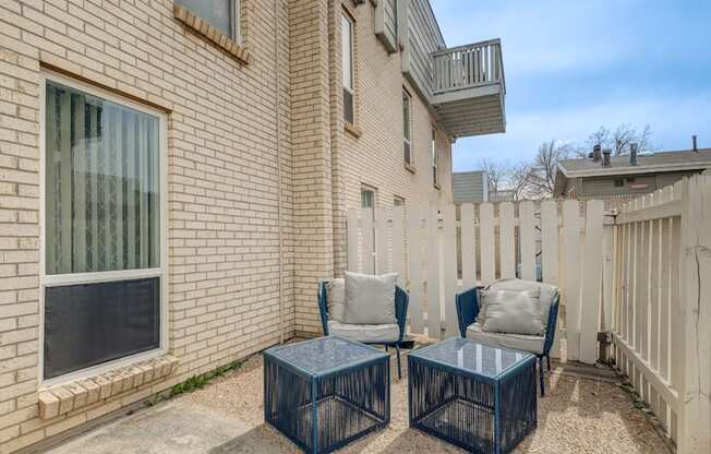 A patio with two chairs and a table.