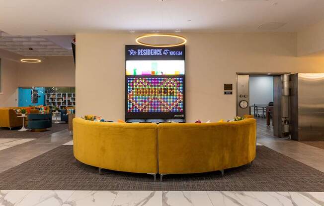 the lobby of a hotel with a large yellow couch in the center of the room