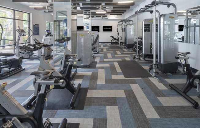 a fitness room with cardio machines and other exercise equipment at The Hendrix, Atlanta, GA, 30329