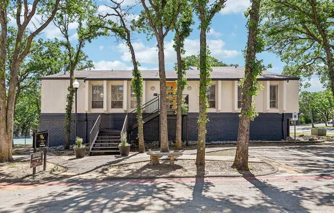 A building with a grey facade surrounded by trees.