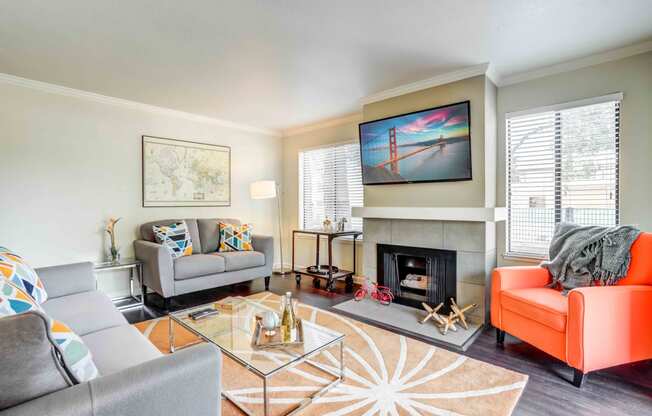 Apartments for Rent in Walnut Creek, CA - Park Lake at Walnut Creek - Furnished Living Room with a Cozy Fireplace, Distinctive Wood-Style Flooring, Two Large Windows, and Stylish Decor