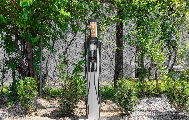 a gas pump sitting in front of a fence