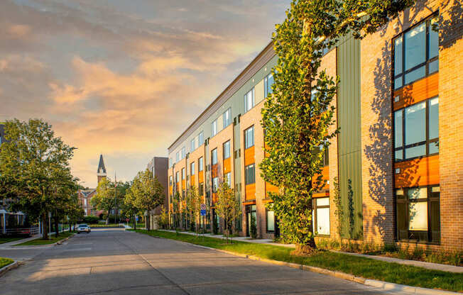 a city street with a brick building and a church in the distance at Canary Lofts, Des Moines, 50311