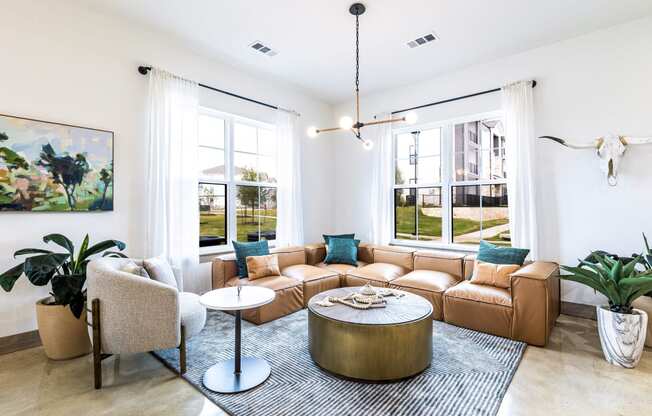 Living room with a leather couch and a round coffee table at The Parker Austin, Pflugerville, TX, 78660