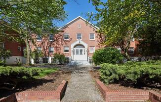 a large brick building with a white door at MILEPOST 5 Apartments, PORTLAND Oregon