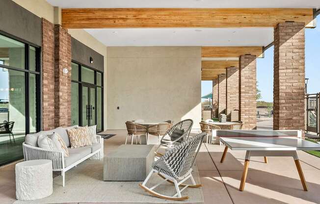 A modern outdoor patio with a white sofa, chairs, and a coffee table.