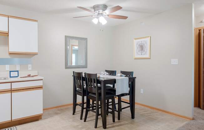 a dining room with a table and chairs and a ceiling fan