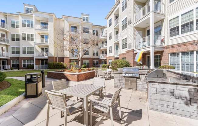 a patio with a table and chairs next to an apartment building  at The Lena, Raritan, New Jersey