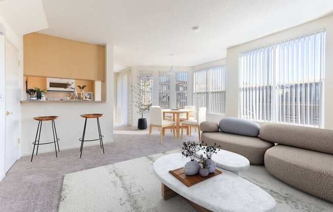 A modern living room with a bar area and a grey sofa.