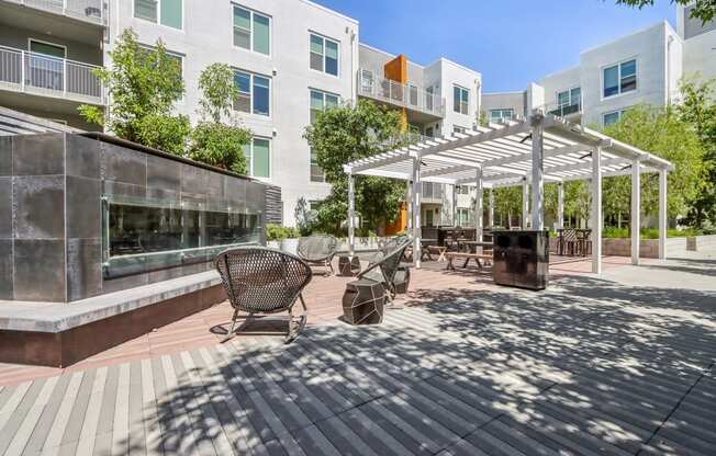 a patio with awnings and benches in front of an apartment building