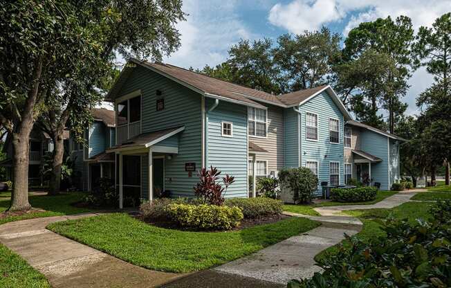 a blue house with a sidewalk in front of it