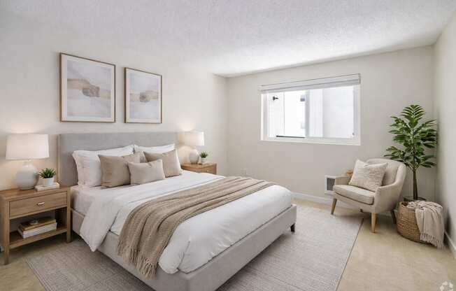 A bedroom with a large bed and a chair.