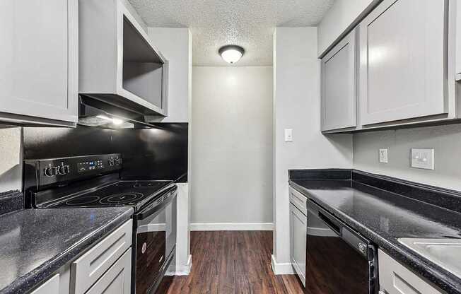 A kitchen with black countertops and white cabinets.