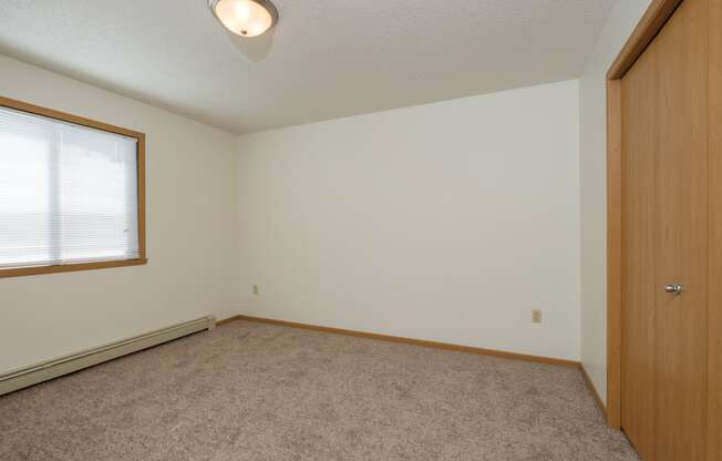 a bedroom with a window. Fargo, ND Twin Parks Apartments.