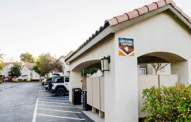 A leasing center with a parking lot in front.