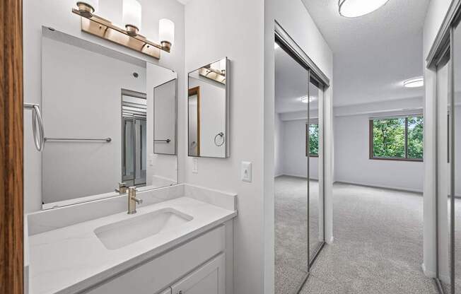 A bathroom with a sink, mirror, and a window.