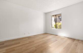 A room with wooden flooring and a window.