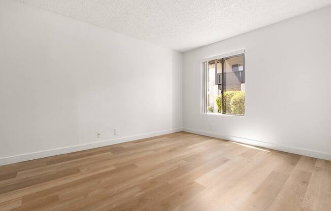 A room with wooden flooring and a window.