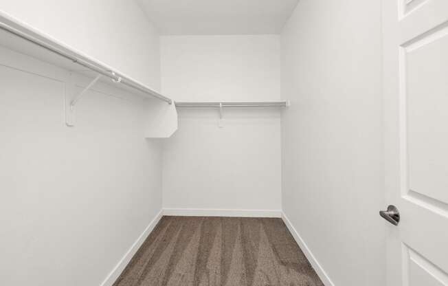 an empty room with white walls and carpet and a white closet