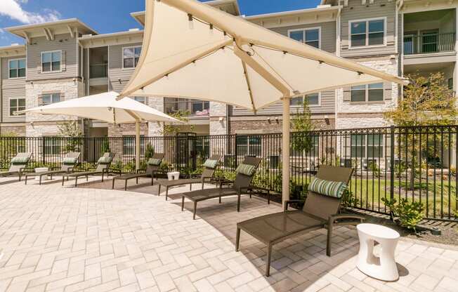 Poolside Relaxing Chairs at Cue Luxury Apartments, Texas