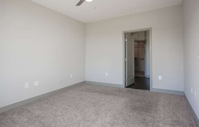 an empty living room with carpeting and a door to a hallway