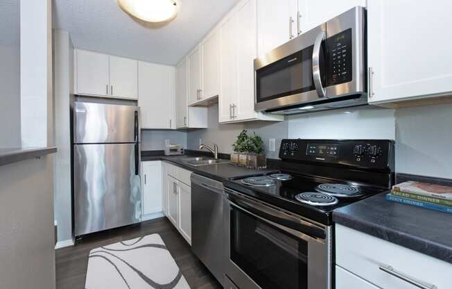 Hinton Height_Cottage Grove_MN_a kitchen with stainless steel appliances and white cabinets