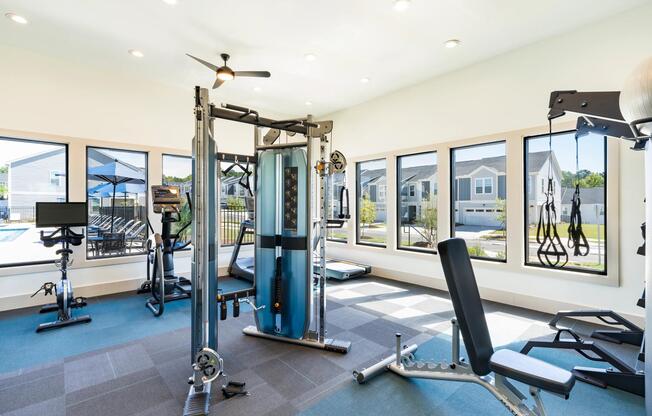 The fitness center features cardio and strength-training equipment, abundant natural light, and pool views that create an energizing environment for daily workouts.