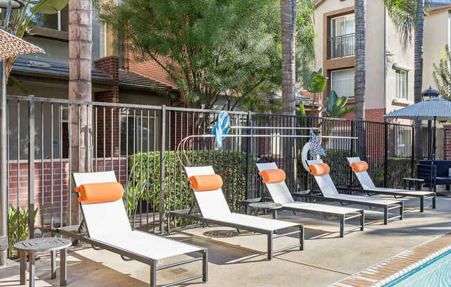 A poolside area with sun loungers and a table.