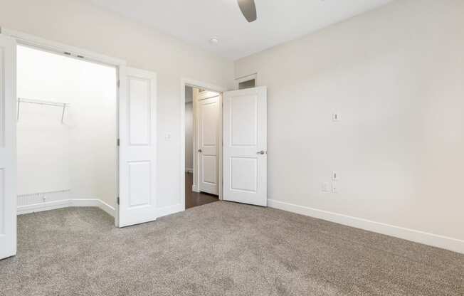 a bedroom with white walls and carpet and white doors