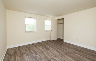 a bedroom with hardwood floors and white walls