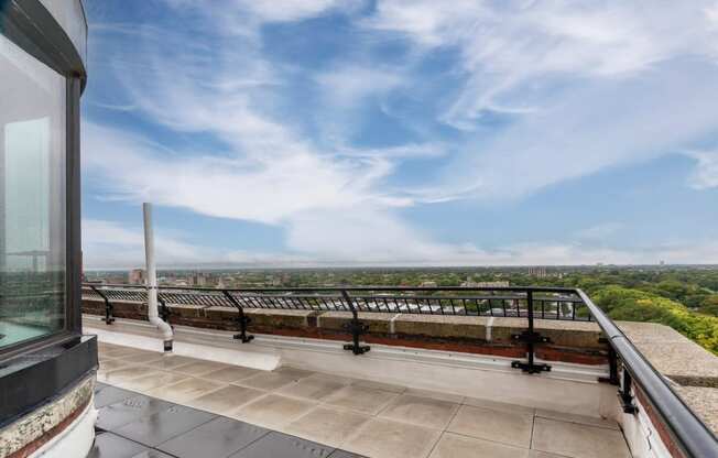 a balcony with a view of a city and a blue sky