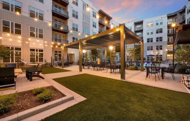 an outdoor patio with tables and chairs at an apartment complex