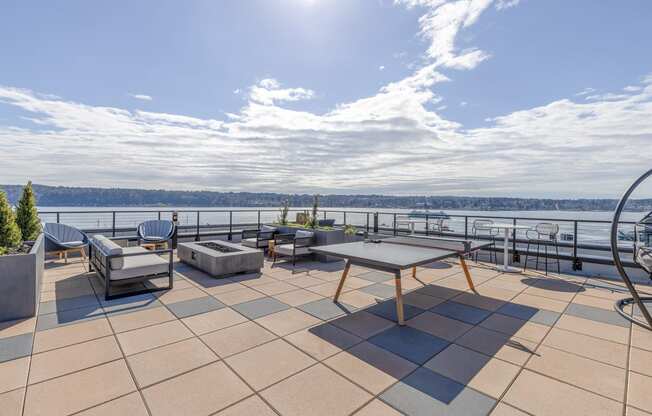 a large terrace with a ping pong  at Marina Square, Bremerton, WAtable and a view of the water