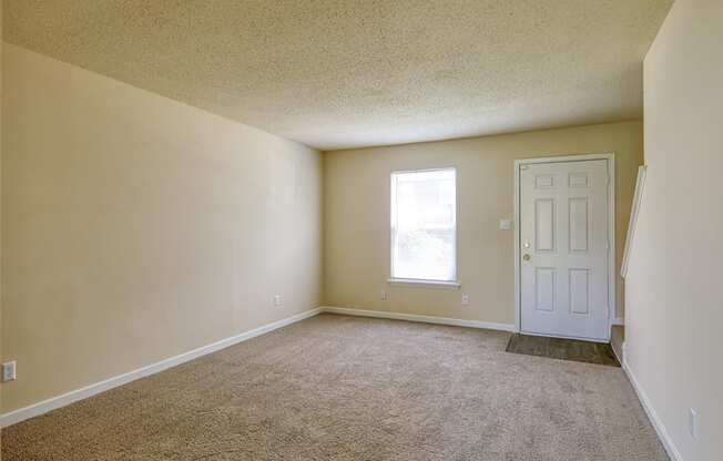 A room with a carpeted floor and a white door.