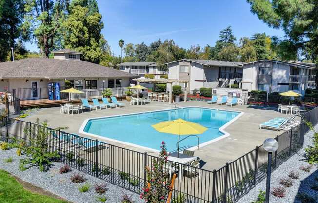 Swimming pool area which is fenced and multiple lounging options around the pool deck. at Renaissance Park Apartments, California