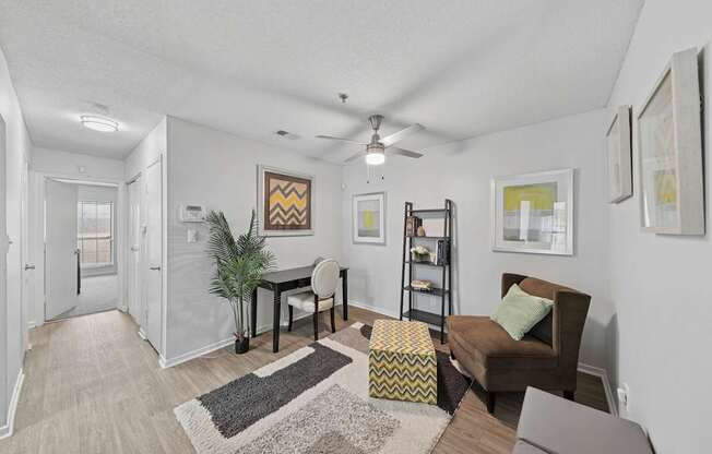 A living room with a brown chair and a yellow and black ottoman.