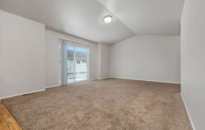 A room with a carpeted floor and a window.