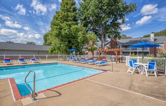 Large pool with sunbathing chairs and tables at St. Croix Apartments in Virginia Beach VA