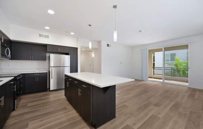 A modern kitchen with dark brown cabinets and a white island.