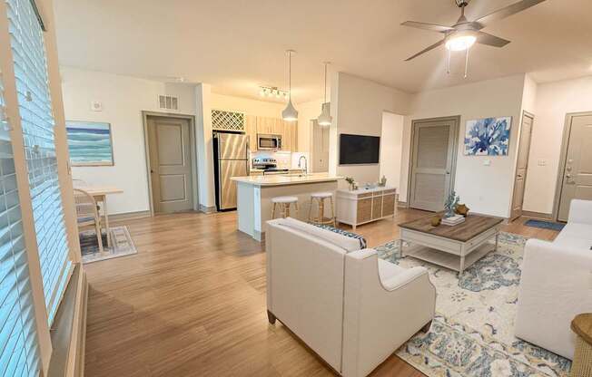 A living room with a white couch and a wooden floor.