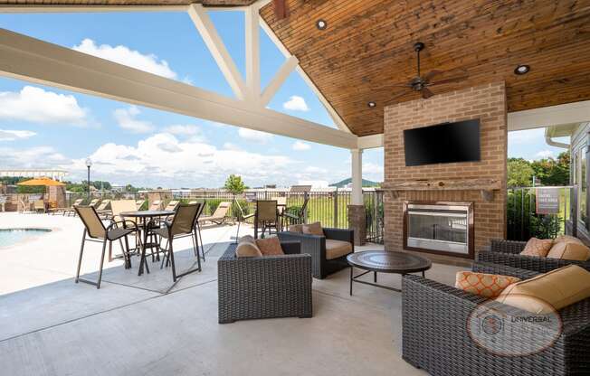 a covered patio with furniture and a fireplace