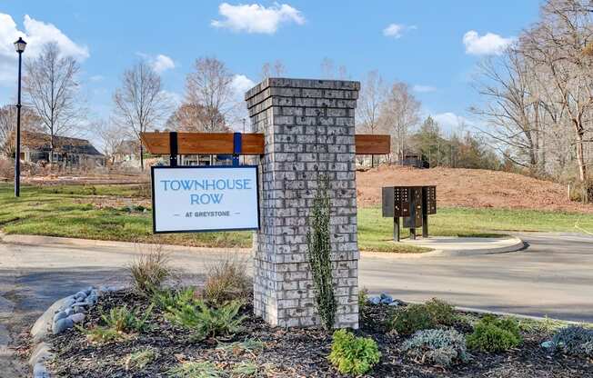 a townhouse row sign in front of a road