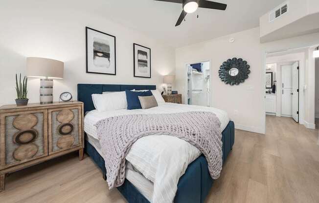 A bedroom with a bed, nightstand, and a ceiling fan.