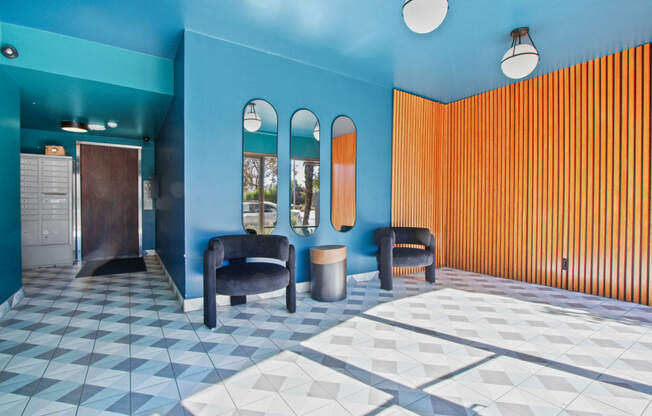 a lobby with blue walls and chairs and a checkered floor